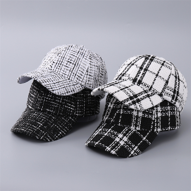 Four black and white plaid baseball caps arranged in two stacks, showing bold and fine check patterns.