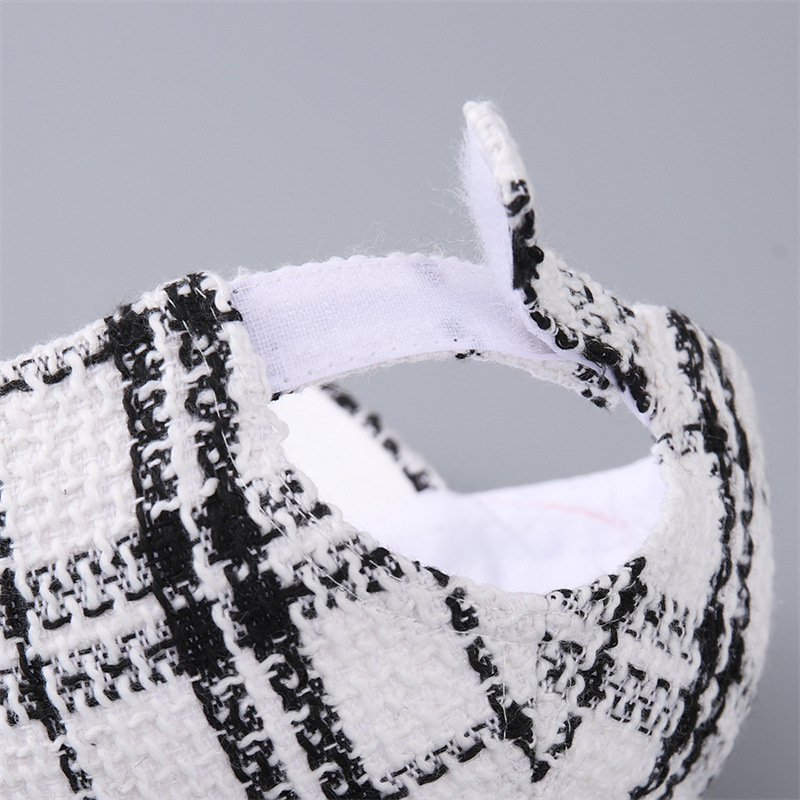 Rear opening of the plaid cap with the white hook-and-loop adjustment strap open.