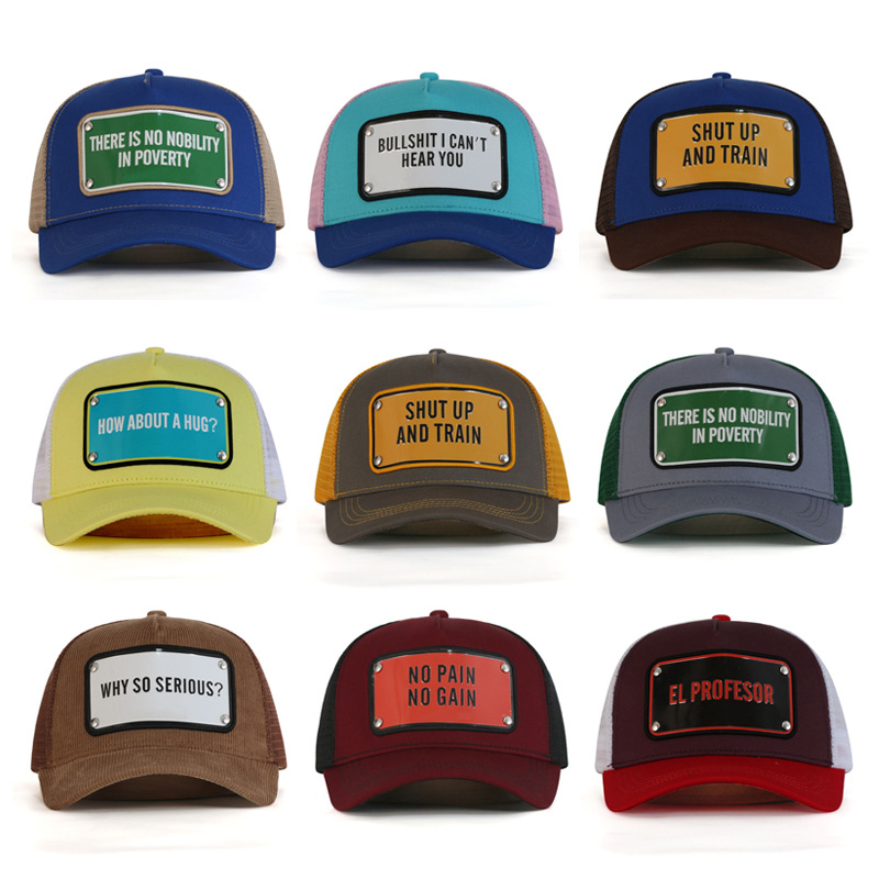 Nine mesh trucker hats in assorted colors with rectangular slogan badges and curved brims.