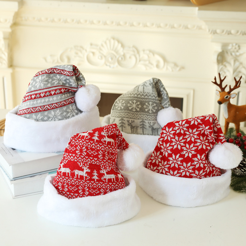 Four knitted Christmas hats in red and grey patterns with white plush cuffs and pom-poms.