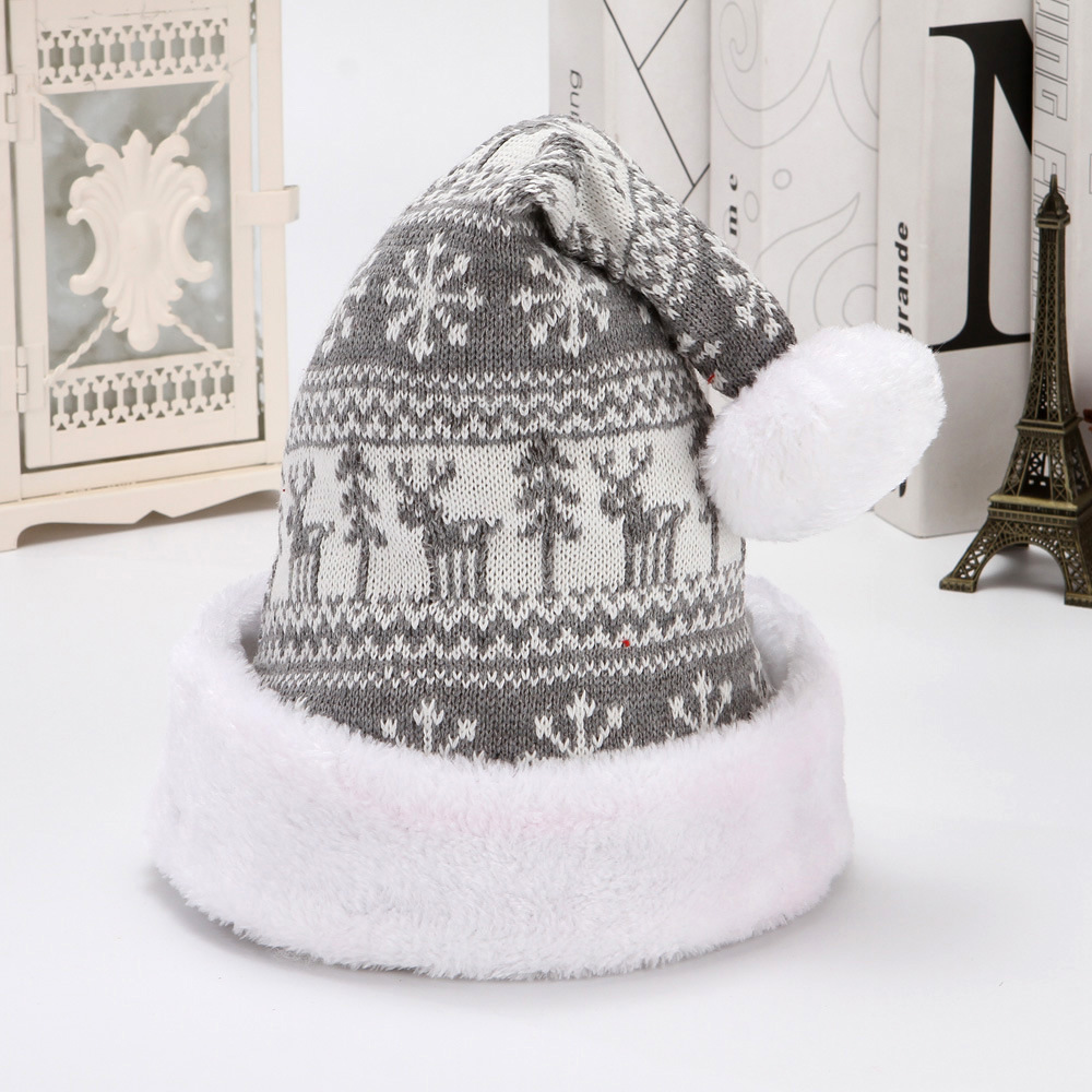 Grey knitted Christmas hat with reindeer and snowflake motifs, a white plush cuff and pom-pom.