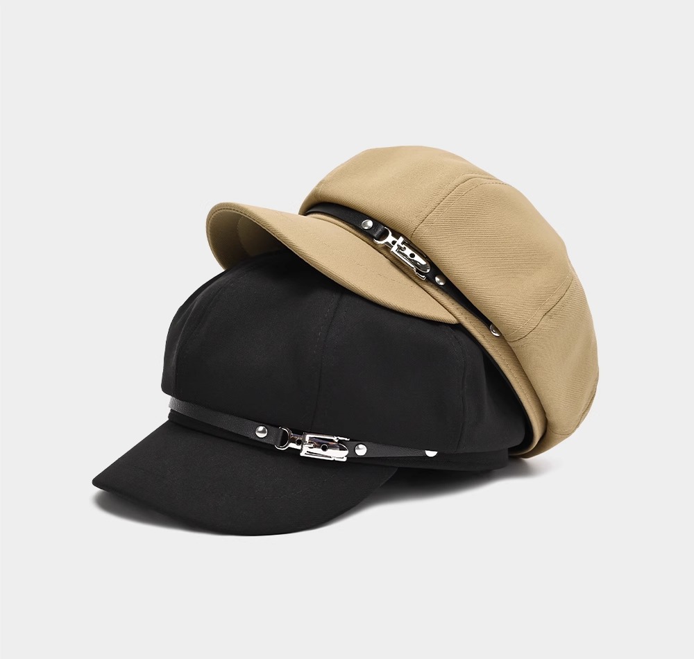 Black and khaki newsboy caps stacked to show short brims and decorative front bands