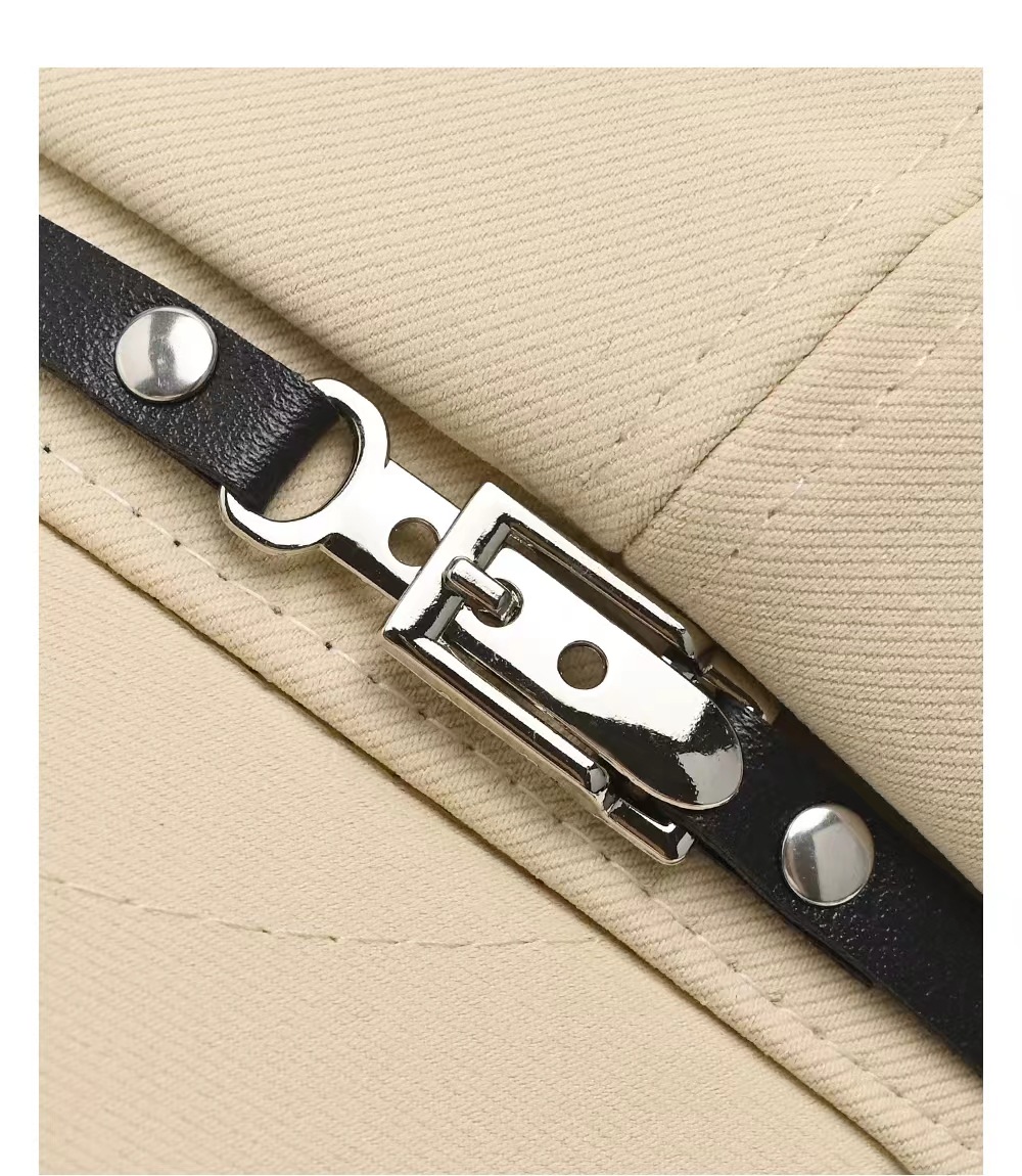 Close-up of the black decorative band, silver-tone clasp and studs on a light-colored cap