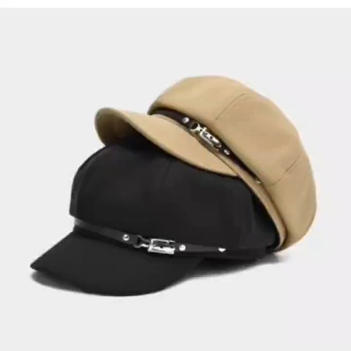 A slideshow zooms in on black, light beige and khaki newsboy caps, followed by crown views and close-ups of the decorative front hardware, lining and adjustment ties