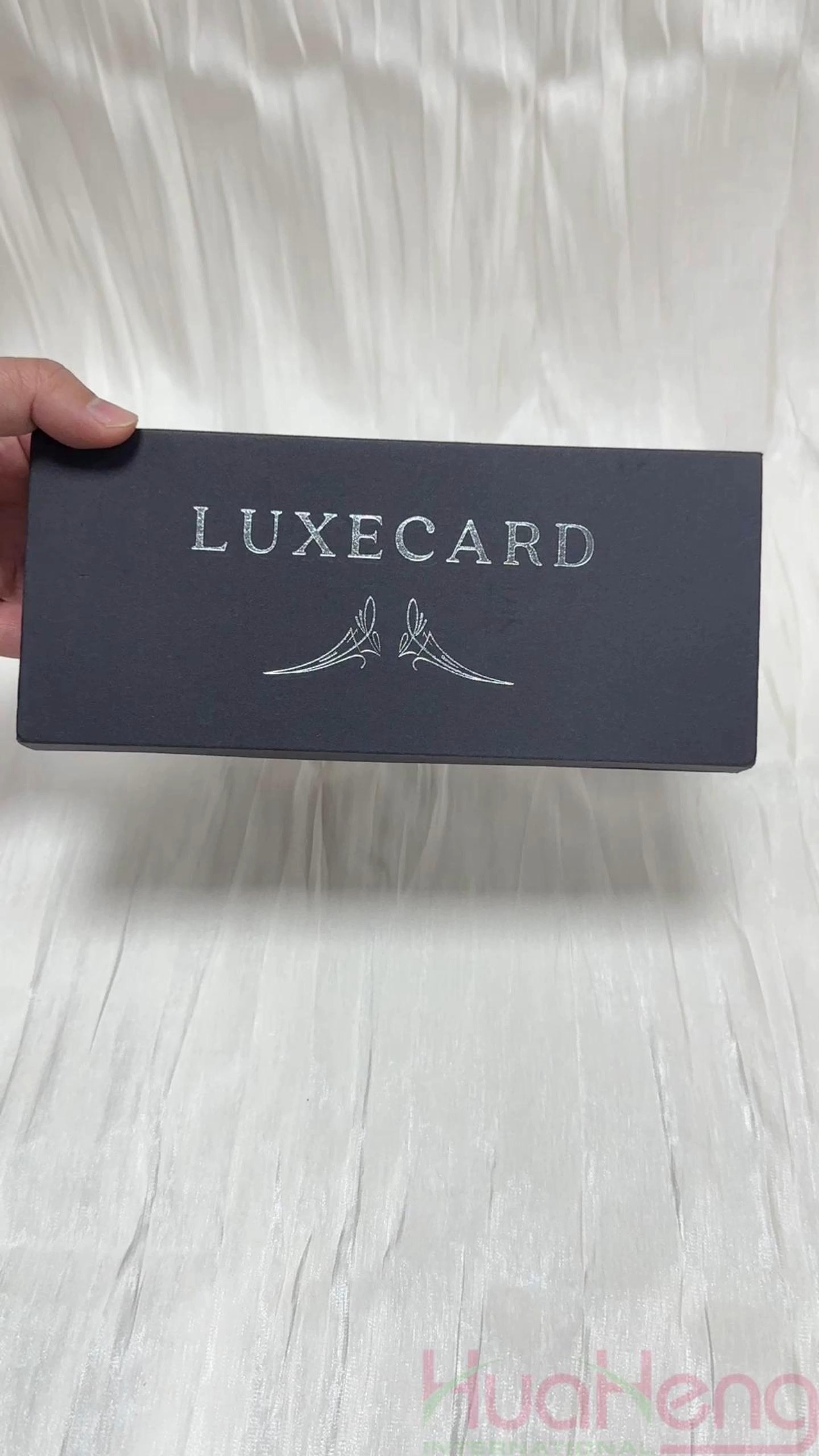 Zwarte flip-top magnetische boekstijlbox met zilveren hotstempeld logo: een premium cadeaubon voor lidmaatschap en aangepaste bankkaarten