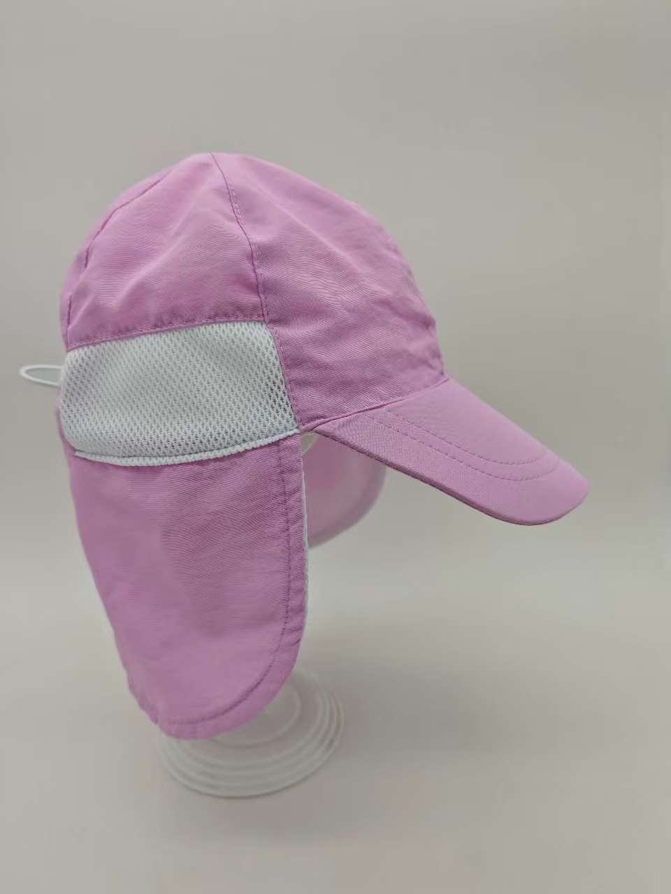 Side view of a purple kids cap with a white mesh panel and long neck flap.