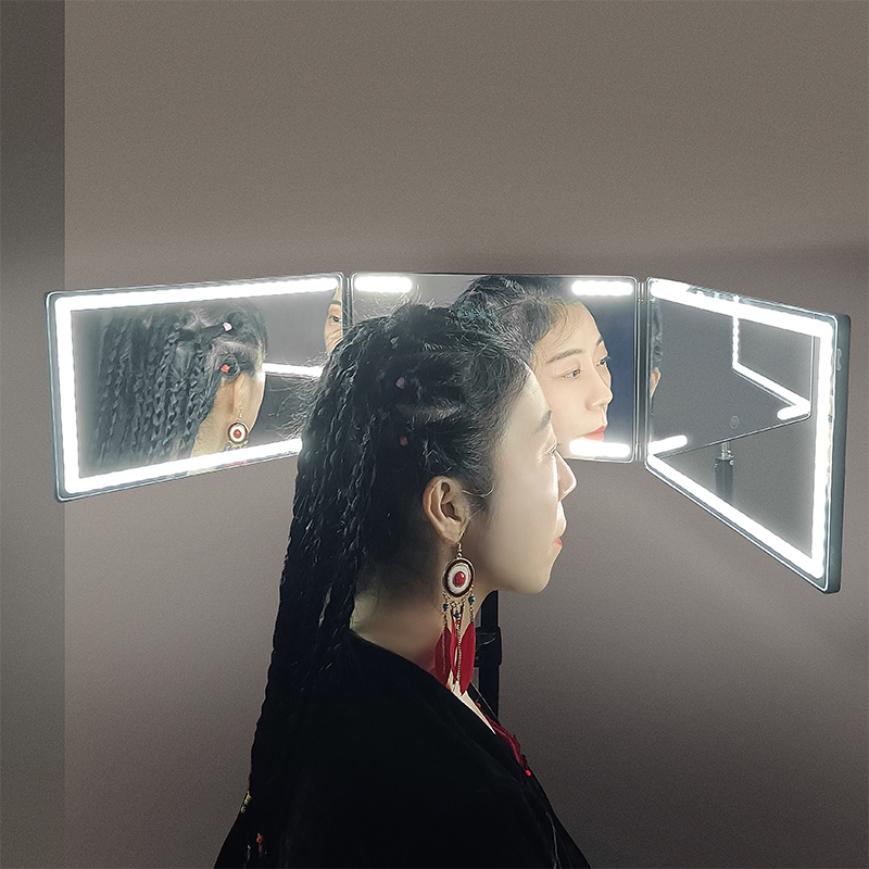 Miroir à trois volets – Femme regardant ses cheveux tressés sous plusieurs angles