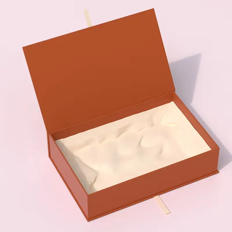 علبة هدايا فاخرة مستطيلة الشكل بلون العاج مصنوعة من ورق قابل لإعادة التدوير، مزودة بإغلاق مغناطيسي وحواف بيضاء وشعار منقوش، وبطانة إسفنجية للكتاب. 1