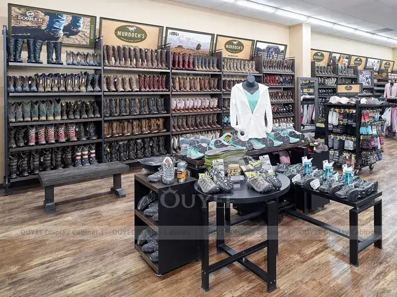 Móveis para boutique de roupas em tons de madeira com araras centrais para roupas. 1