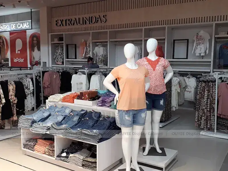 Agencement de vitrines de magasins de mode avec mannequins et présentoirs centraux 1
