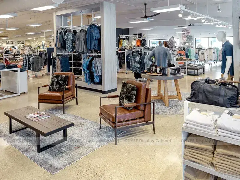 Mobiliário branco para showroom de roupas com araras centrais para vestuário. 1