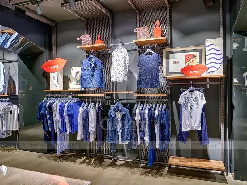 Parede de roupas boutique em tons terrosos com prateleiras sobrepostas 1