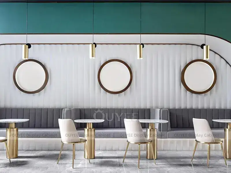 Bancone da caffetteria color verde acqua con soffitto a doghe e specchi rotondi a parete. 1