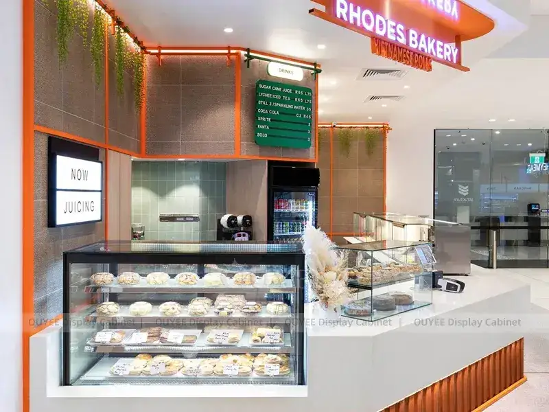 Comptoir de boulangerie Rhodes avec mur d'exposition vert et panneaux de bois chaleureux 1