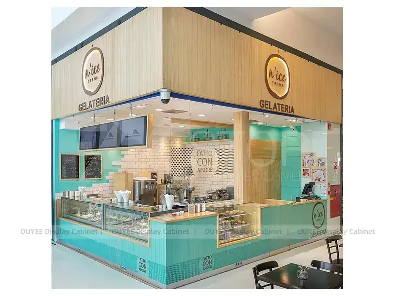 Bancone da gelateria turchese con grafiche a parete a forma di cono e vetrina. 1
