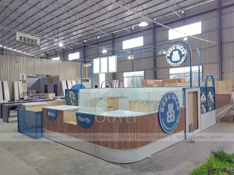 Kiosque à boissons industriel bleu avec comptoir en bois incurvé et logo rond 1