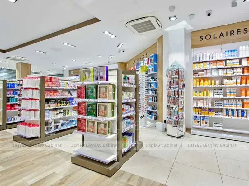 Interno di farmacia color verde tenue con vetrine centrali sospese. 1