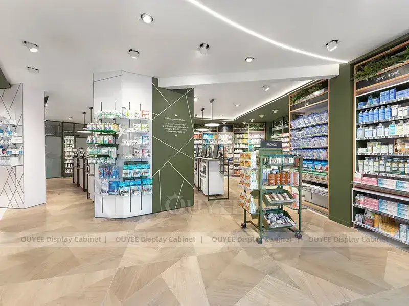 Corsie della farmacia con colonne verdi e scaffali espositivi su ruote. 1