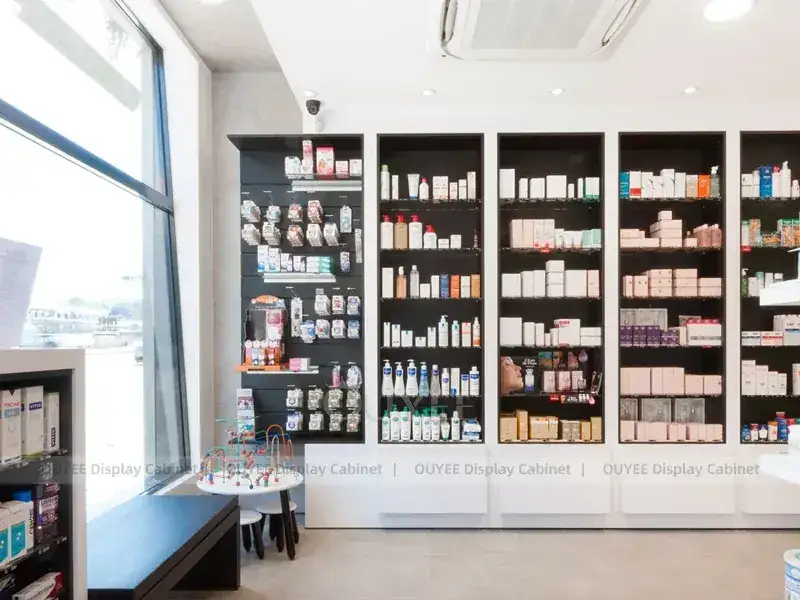 Schwarz-weißer Apothekentresen mit langen, hinterleuchteten Wandregalen 1