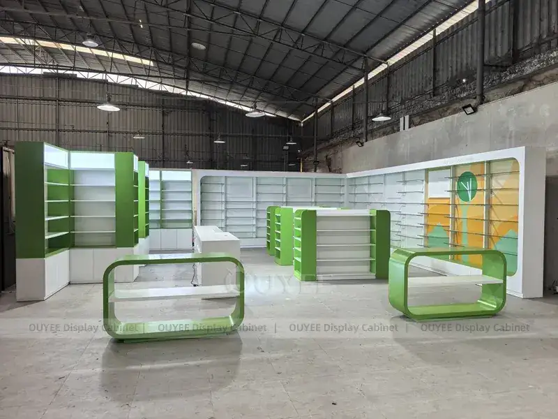 Bancone da farmacia curvo verde con scaffalature a gondola abbinate. 1