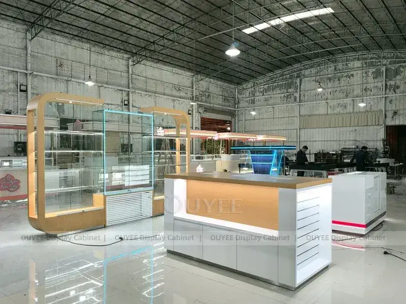 Mobiliário para loja de celulares em tons de madeira e dourado, com painéis de marca vibrantes para áreas de exposição de acessórios. 1