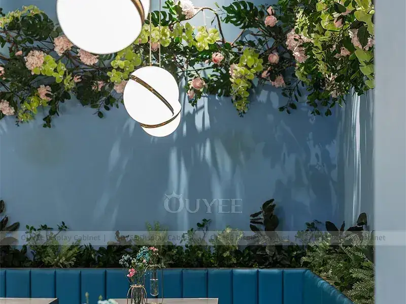 Inneneinrichtung für ein Café in Holzoptik mit blauem Rand, goldenen Zierelementen und Glasvitrine 1
