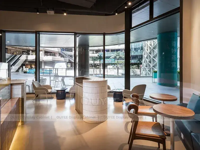 Balcão expositor de café em madeira com detalhes dourados e vitrine de vidro para projetos de cafeterias independentes. 1