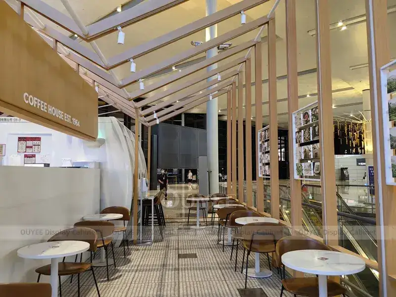 Aménagement intérieur de café avec boiseries dorées, garnitures dorées et vitrine en verre pour projets de cafés indépendants 1