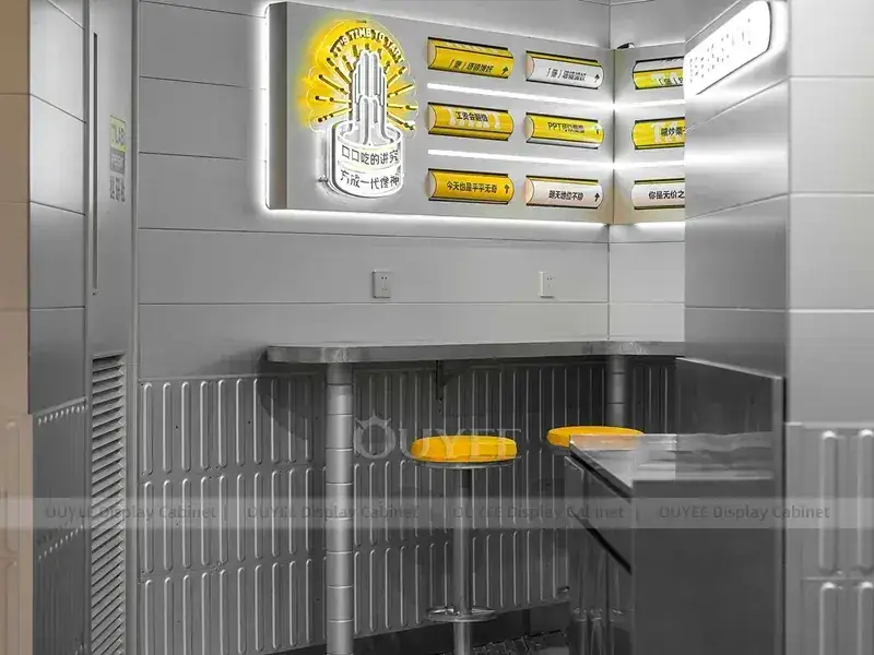 Bedienungstheke in Holzoptik mit goldener Tischplatte, gelber Thekenfront und Flaschenwand 1