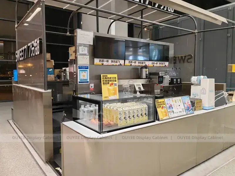 Comptoir de café orange ton bois avec garniture dorée et vitrine en verre pour projets de cafés indépendants 1