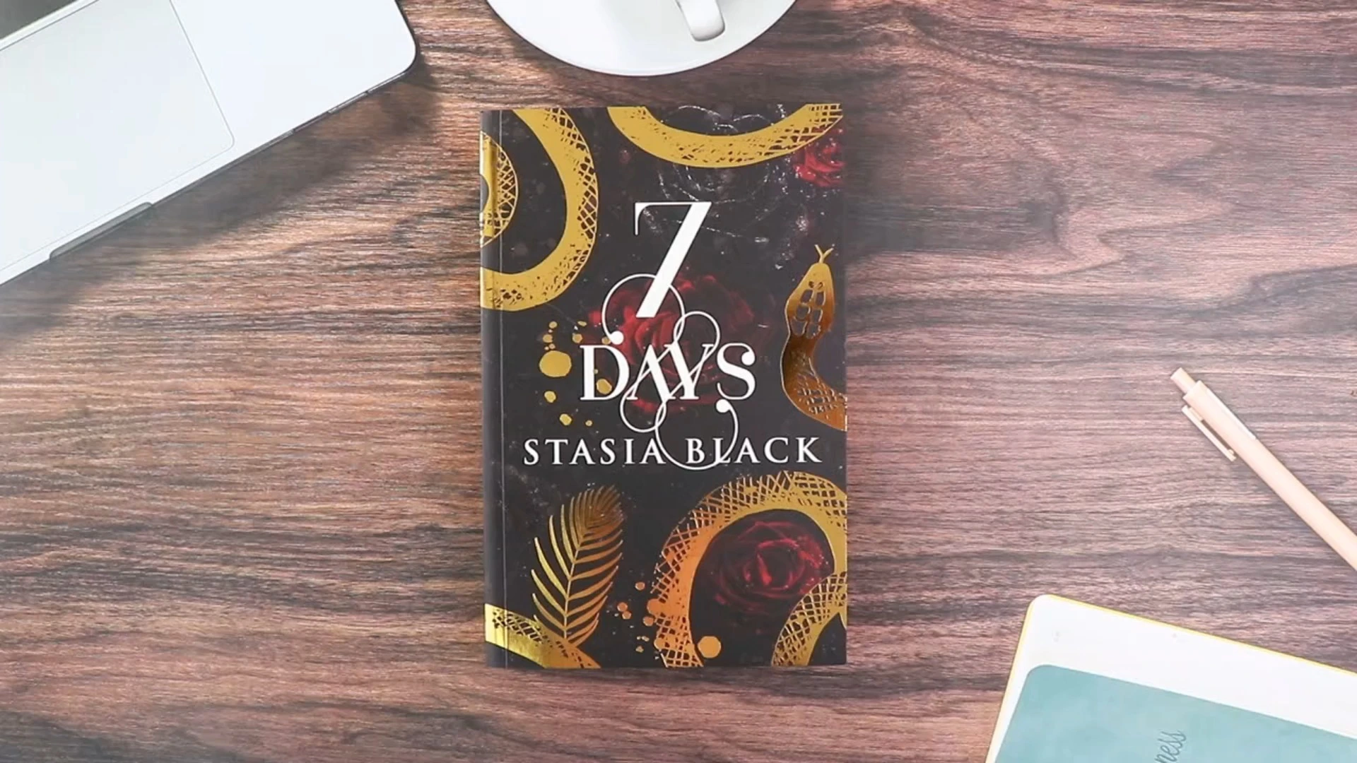 Novela de fantasía con tapa blanda con detalles en lámina de oro, diseño con bordes pintados y páginas en blanco y negro. 1