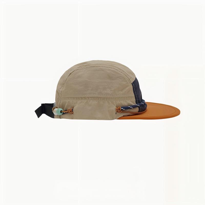 Side view of a beige camper cap with an orange brim, cord trim, pale bead and black rear strap.