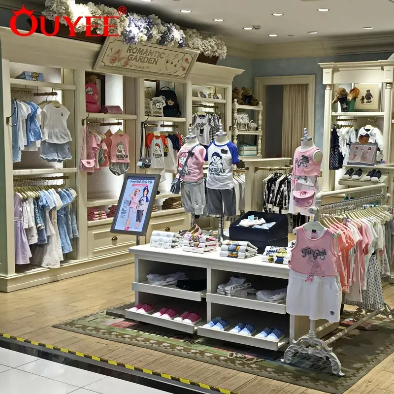 Espositore in legno bianco per interni di negozi di abbigliamento per bambini e neonati. 1