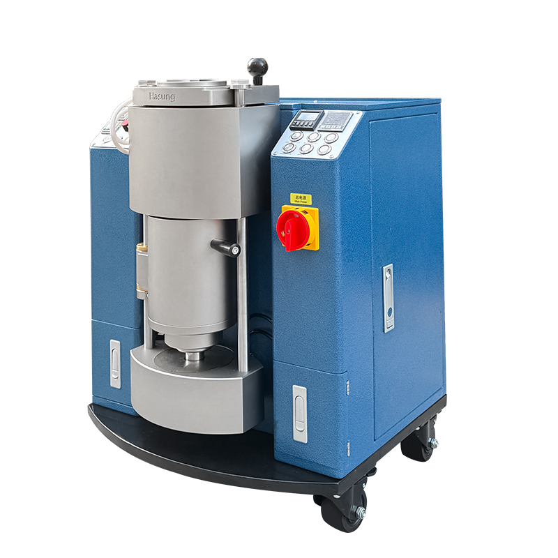 Angled right-side view of the small vacuum pressure casting machine, highlighting its space-saving design and safety emergency stop button.