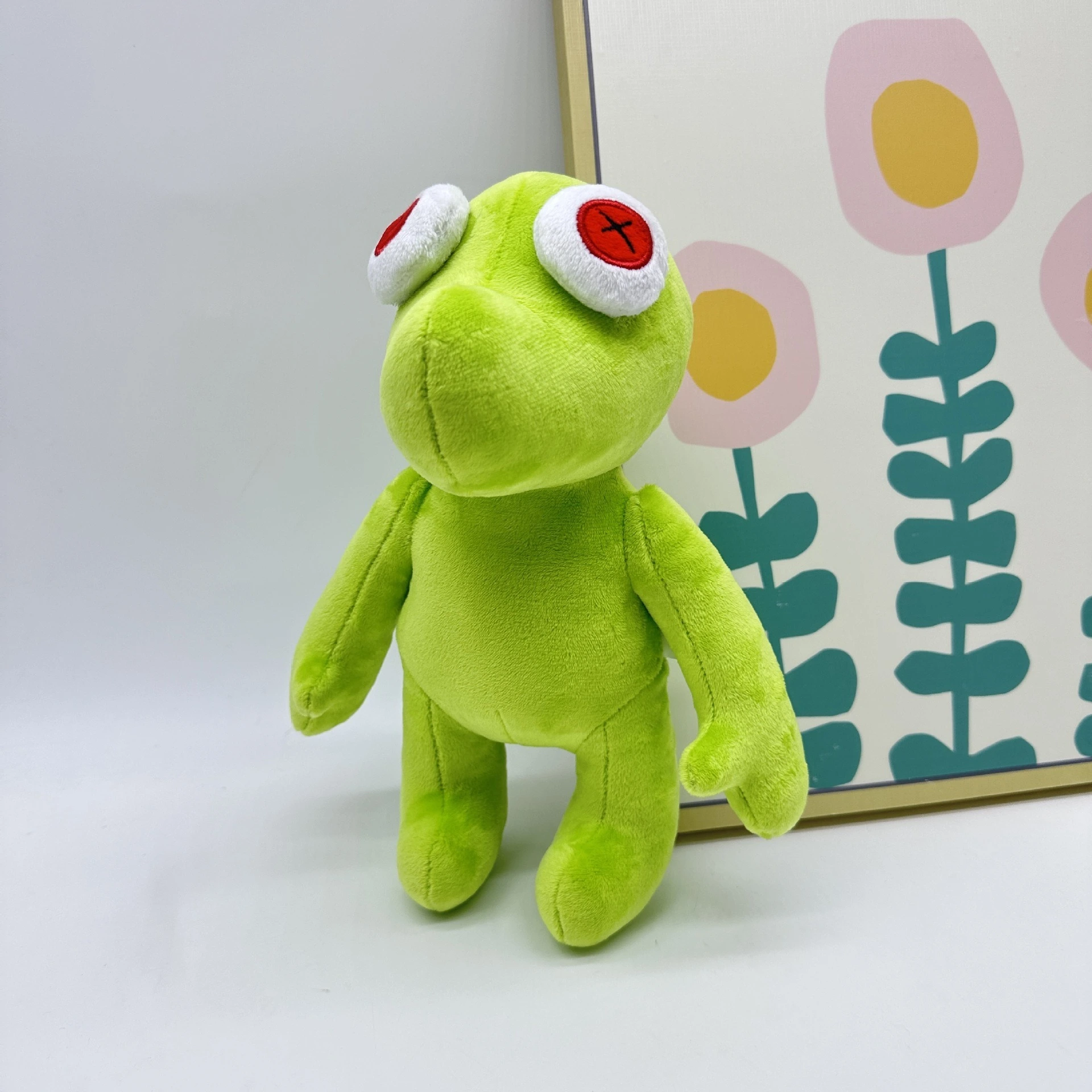 Peluche Petite Grenouille Verte Vibrante Runmo - Poupée en Peluche de 26 cm avec des yeux en croix rouge 1