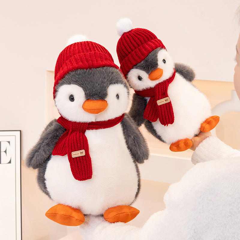 Penguin plush toy wearing a red hat and scarf, with a unique and creative design featuring cute animals to accompany 13
