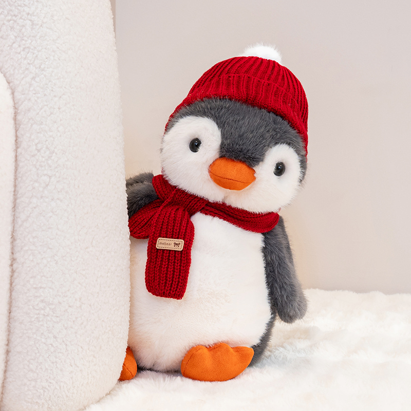 Penguin plush toy wearing a red hat and scarf, with a unique and creative design featuring cute animals to accompany 12