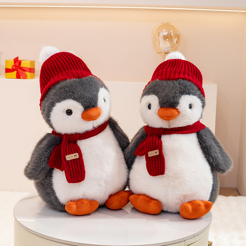 Penguin plush toy wearing a red hat and scarf, with a unique and creative design featuring cute animals to accompany 16