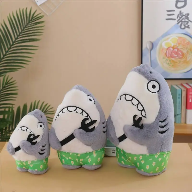Petit requin en peluche rigolo avec fourchette, à petit prix de gros, idéal pour une fête d'anniversaire ou comme cadeau amusant. 1