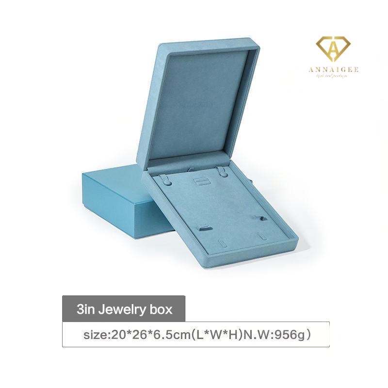 Spacious blue jewelry box holding necklace and bracelet, elegant microfiber finish