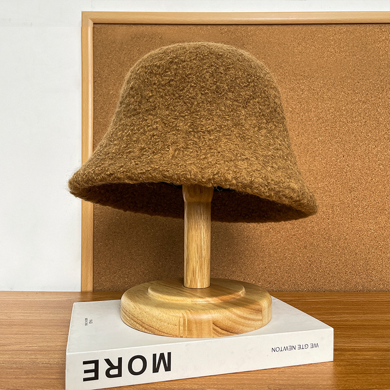 Tan bucket hat with a textured surface, rounded crown and downturned brim.