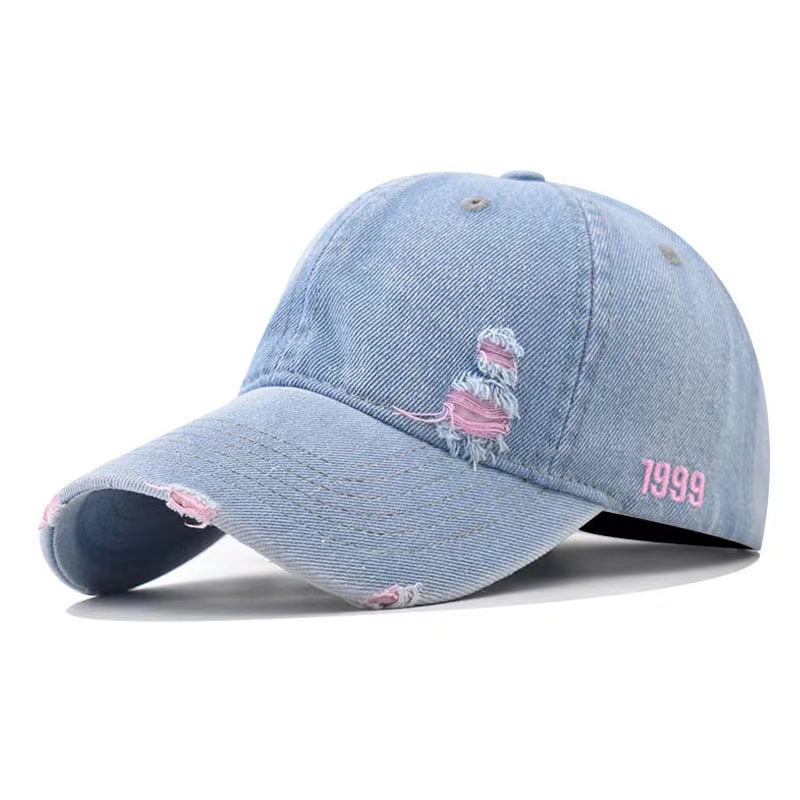 Light blue denim baseball cap with pink accents at the frayed front and brim.