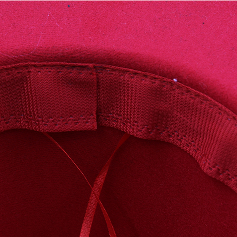 Close-up of a red hat interior showing a stitched band and thin ties.