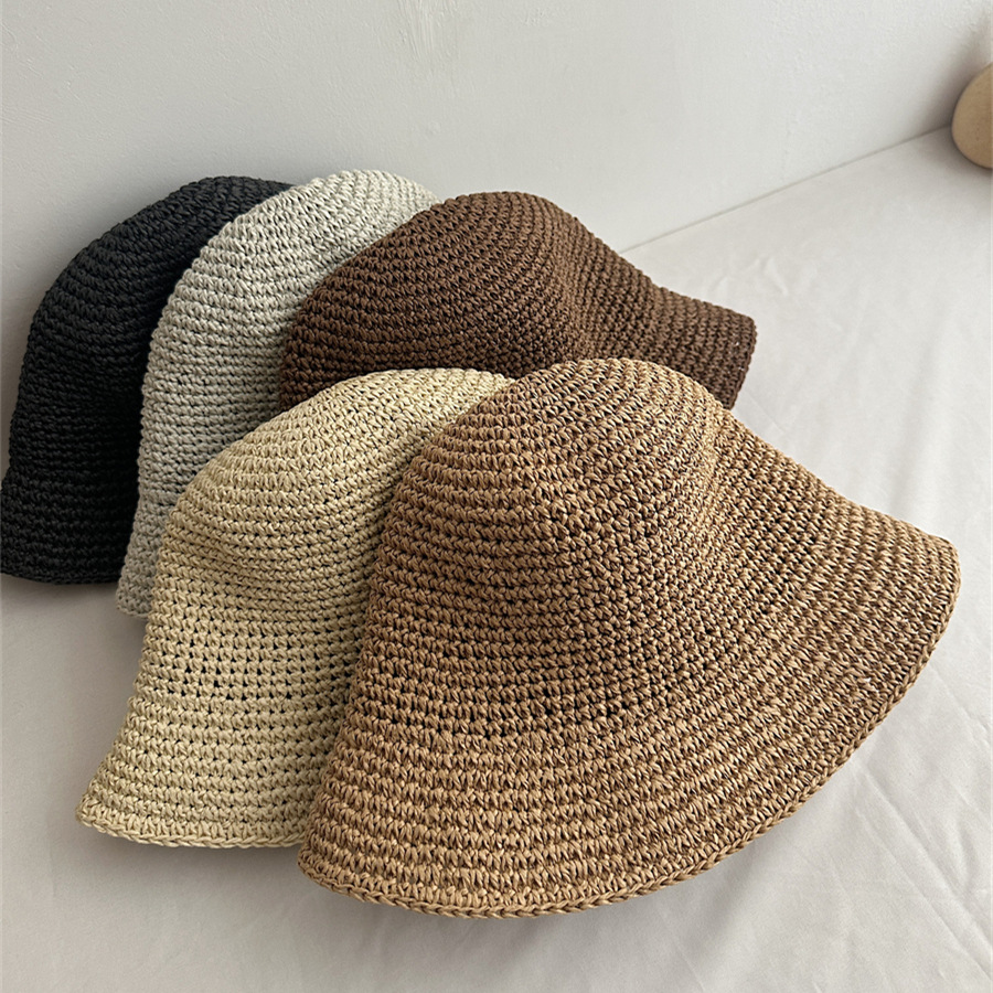 Five woven bucket hats displayed with the khaki hat closest to the camera