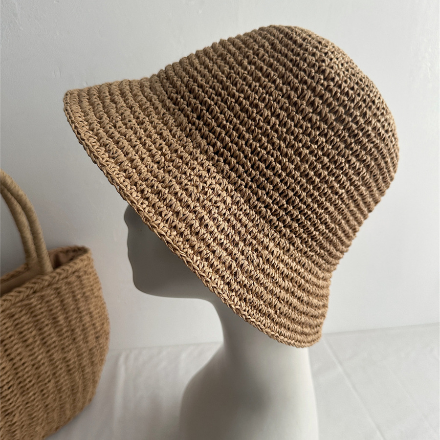 Khaki woven bucket hat on a mannequin with a rounded crown and sloping brim