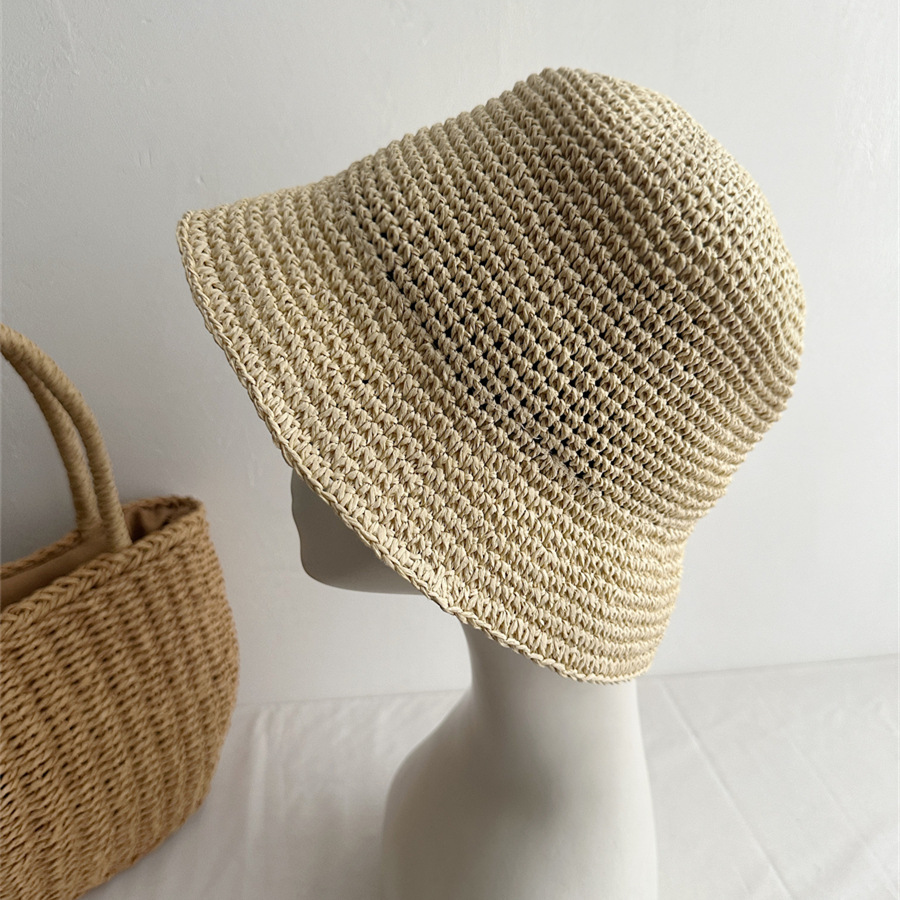 Beige woven bucket hat shown in profile on a mannequin