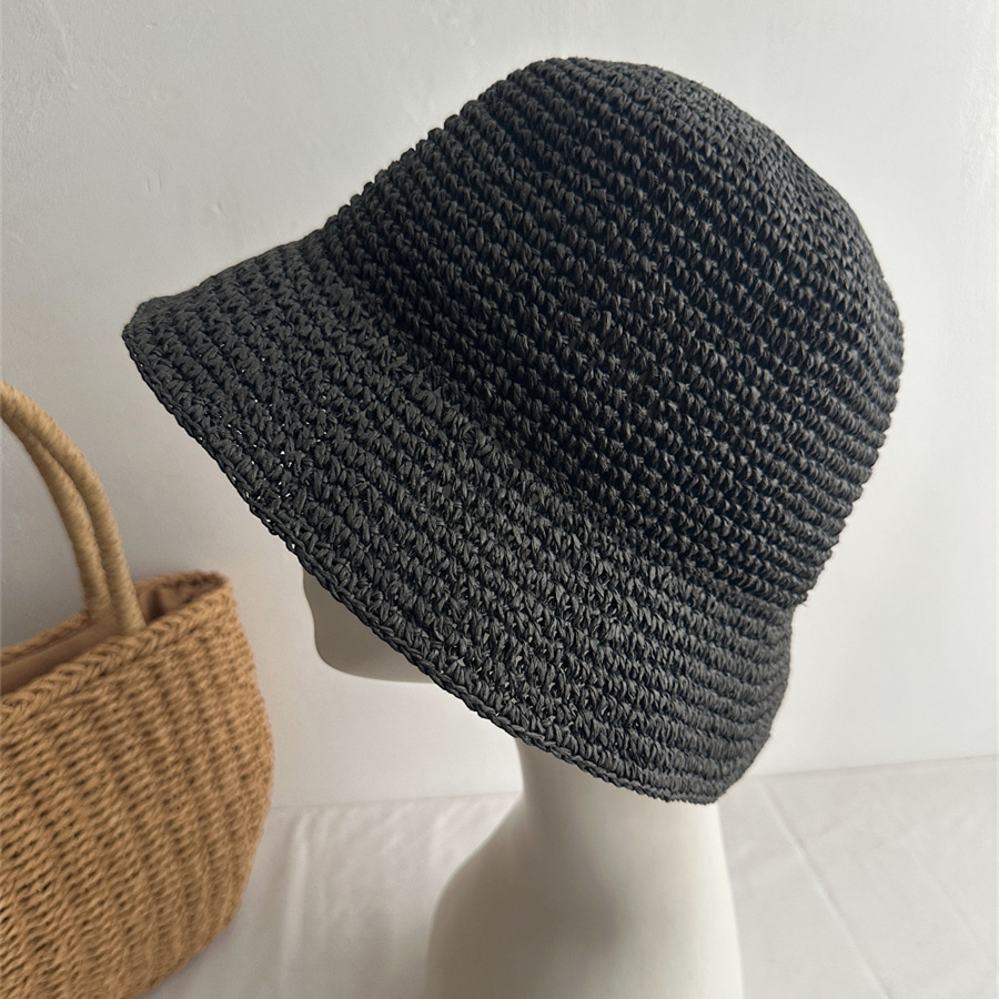 Black woven bucket hat on a mannequin with a downward-sloping brim