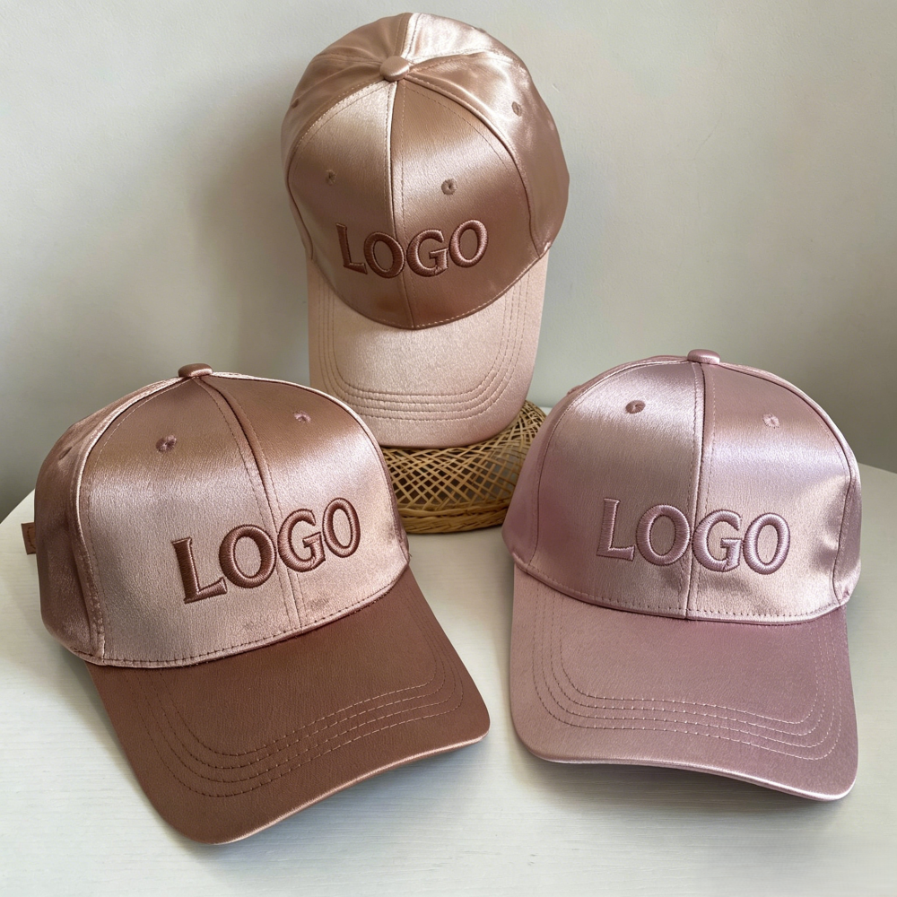 Three satin baseball caps in champagne and pink tones with front logo embroidery examples