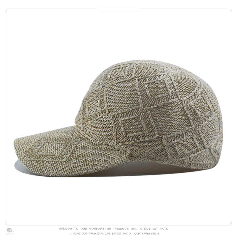 Side view of a beige openwork knit baseball cap with a curved brim and diamond pattern