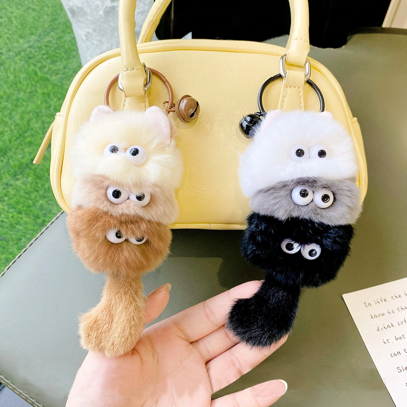 A cartoon plush keychain with three little cats sitting on top of each other! 1